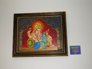 Framed colorful painting of elephant and two god-like figures in red temple scene