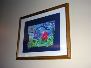 Framed painting of one red and one blue flower with blue sky and red sun in background
